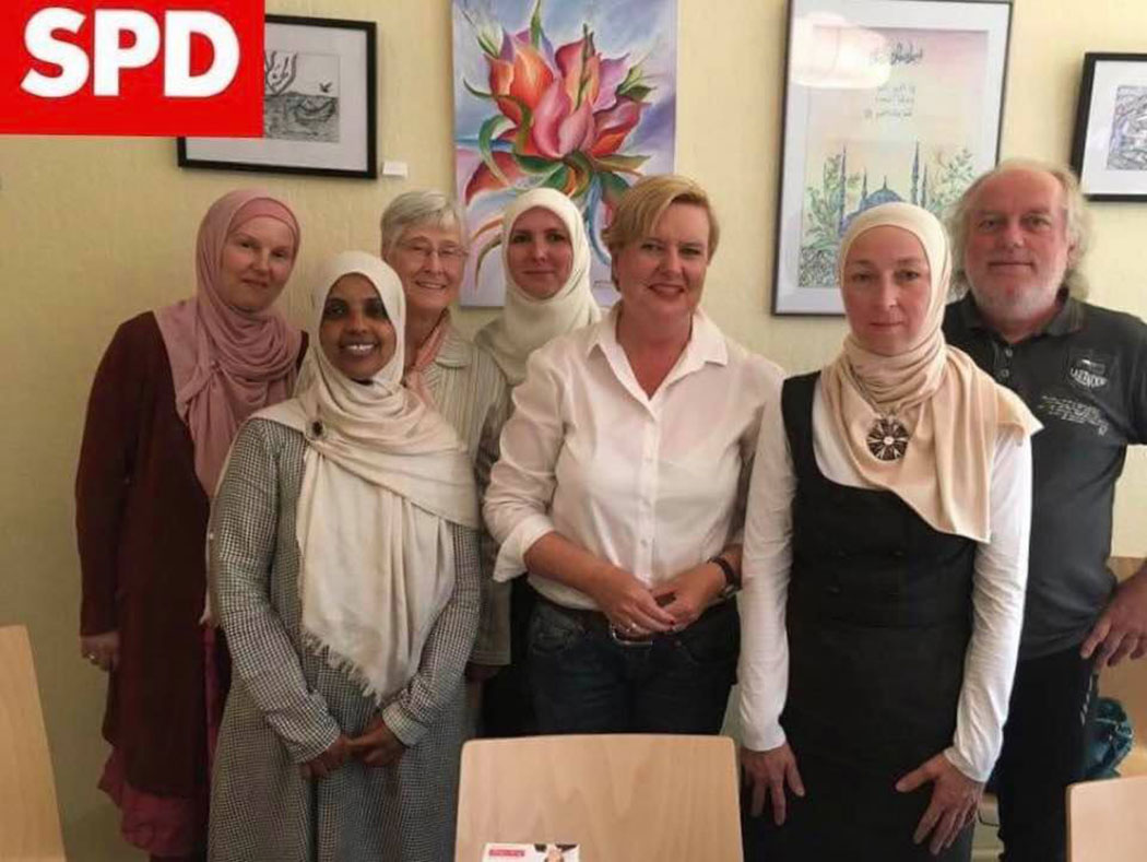 Rechts ein biodeutscher Spezialdemokrat mit seinem Harem. Die zwei Unbekopftuchten hält er sich zum Putzen.